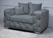 Gray tufted armchair with three cushions on a light wooden floor.
