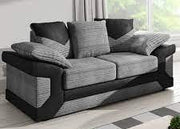 Gray and black sofa with patterned cushions in a room with large windows.