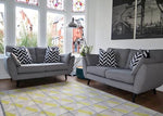 Living room with two gray sofas, black and white patterned cushions, and a colorful rug.