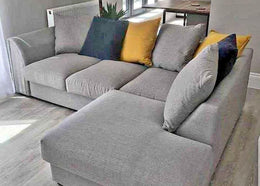 Gray sectional sofa with colorful cushions in a living room setting.