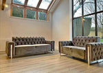Two brown tufted sofas in a room with large windows.