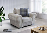 Gray armchair with a plaid pillow in a modern living room setting.