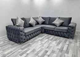 Gray sectional sofa with decorative pillows in a room with gray flooring.