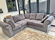 Gray sectional sofa in a living room with large windows.