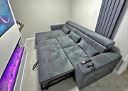Gray sectional sofa in a living room with a TV and decorative items.