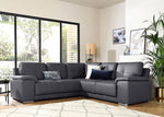 Gray sectional sofa in a living room with large windows and decorative elements.