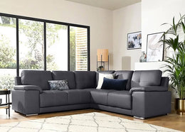 Gray sectional sofa in a living room with large windows and decorative elements.