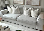 Gray sofa with patterned cushions in a living room setting
