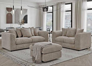 Beige sectional sofa set in a modern living room with large windows.