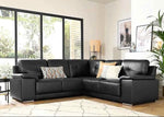 Black leather sectional sofa in a living room with decorative pillows and large windows.