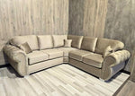 Beige sectional sofa in a room with wooden walls and floor.