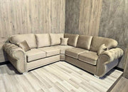 Beige sectional sofa in a room with wooden walls and floor.