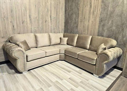 Beige sectional sofa in a room with wooden walls and floor.