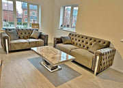 Living room with two beige tufted sofas and a marble coffee table.