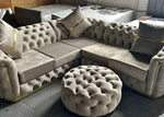 Gray tufted sectional sofa with matching ottoman in a living room setting.
