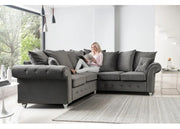 Woman sitting on a gray sectional sofa in a modern living room.