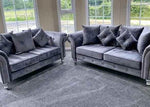 Gray velvet sofa set placed in a modern living room with large windows and natural light.