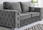 Gray tufted sofa in a room with a patterned rug