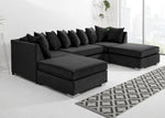 Black sectional sofa in a living room with a patterned rug.