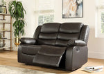 Black leather recliner sofa in a living room setting with decor elements.