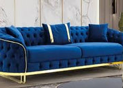 Modern blue sofa with gold legs against a marble wall