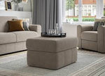 Living room with beige sofa, ottoman, and decor items.