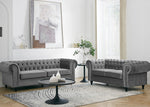 Gray tufted sofa set in a living room with a coffee table and decor.