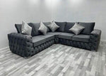 Gray sectional sofa with decorative pillows in a room with gray walls and flooring.