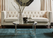 Living room with beige sofa, decorative mirror, and coffee table with vases.
