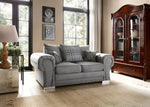 Gray sofa in a living room with a wooden cabinet and large windows.