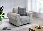 Gray armchair with a plaid pillow in a modern living room setting.