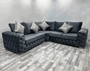 Gray sectional sofa with decorative pillows on a checkered floor.